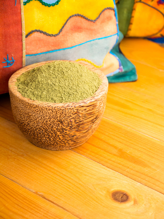 Henna powder hair colourant in the coconut bowl on the bright pillows backgroundの写真素材