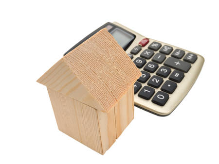House of wooden building blocks with calculator isolated on whiteの写真素材