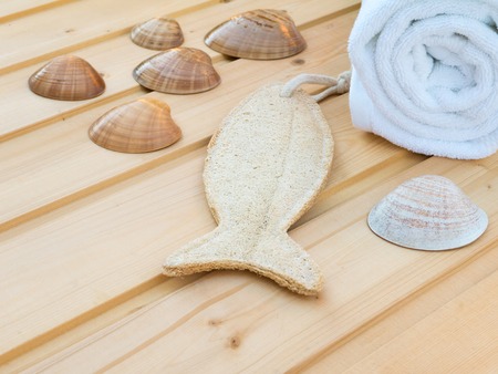 White towel, seashells and fish shaped wisp on the wooden planksの写真素材
