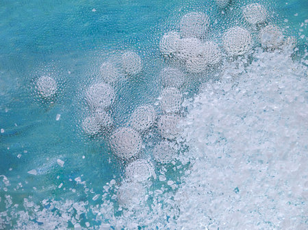 Salt, white stones and misted glass background