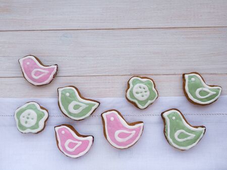 Bird and flower shaped Easter cookies on the white wooden backgroundの写真素材