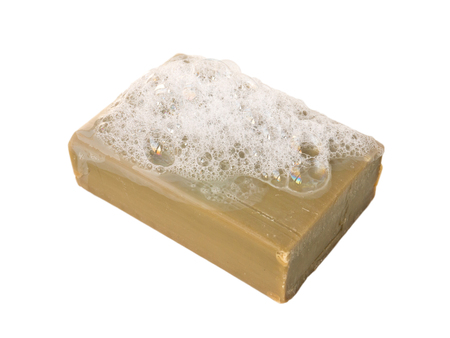 Natural olive oil soap bar with lather isolated on whiteの写真素材