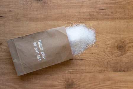 Salt in the paper pack on the table. Throw away, do not eat added salt intake health warning on the...