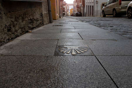 RIBADEO, SPAIN - October 4, 2020: Scallop shell St Jakob's route sign on the stone pavement in the Ribadeo, Lugo, Galicia, Spain.のeditorial素材
