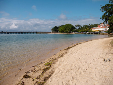 LA TOJA, SPAIN - JULY 24, 2021:Sandy beach, crystal clear sea and bridge at the La Toja island...