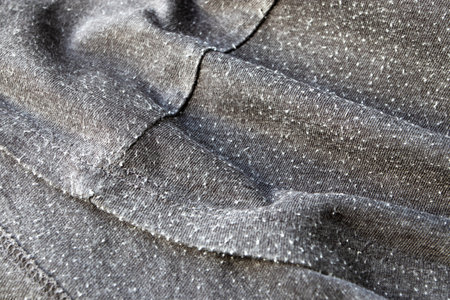 Bobble on the gray cotton knitwear fabric. Lint balls on the clothes. Pill on the wearout t-shirt.の写真素材