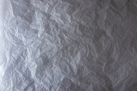 Crinkled white wrapping paper. Light and shadow contrast background.の写真素材