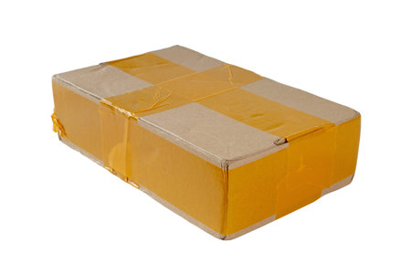 Brown cardboard parcel wrapped with yellow packing tape, isolated on white background. Perfect for...
