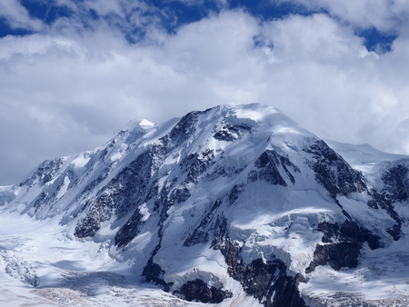 Lyskamm at Monte Rosa massif, landscape of swiss alpine mountain range glacier in Alps, SWITZERLAND, from Gornergrat near Zermatt village, cloudy blue sky in 2017 warm sunny summer day, Europe on Julyの写真素材
