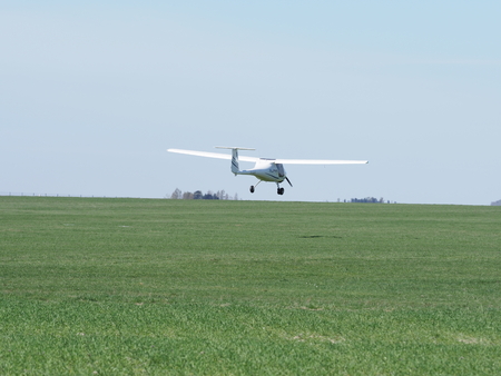 BIELSKO-BIALA, POLAND on APRIL 2018: Close-up to white Pipistrel Alpha Trainer SP-SEAT airplane on grassy airfield, taxiing to takeoff, belongs to air club in european city in warm sunny spring day.のeditorial素材