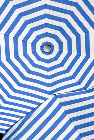 overlapping sun shade umbrellas with white and blue stripesの写真素材