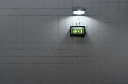 A grungy subway exit sign on a tiled wallの写真素材