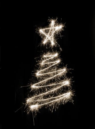 A christmas tree symbol drawn in sparkler trailsの写真素材