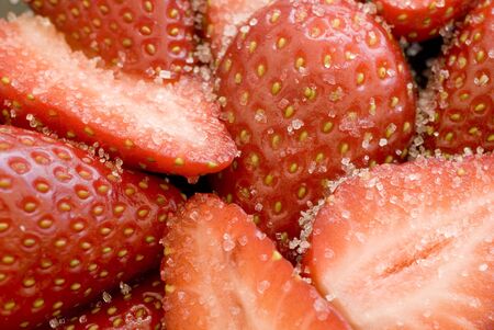close up on some sliced strawberries covered in white sugar granulesの写真素材