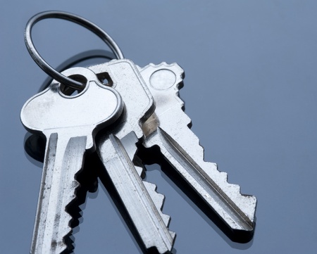 three keys on a keyring with cold coloured lighting, concept of securityの写真素材