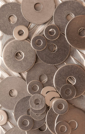 Background abstract pattern and texture of numerous overlapping stainless steel washers in an...