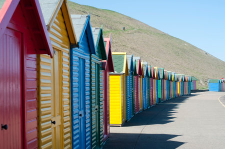 Receding line of colorful wooden beach huts curving away into the distance in a summer vacation and travel conceptの写真素材