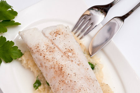 Filet from cod with mashed celery and paisley and a fish knife and fork
