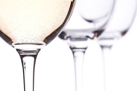 Three glasses with white wine in the backlight with white backgroundの写真素材