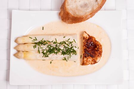 White asparagus with roasted chicken and breadの写真素材