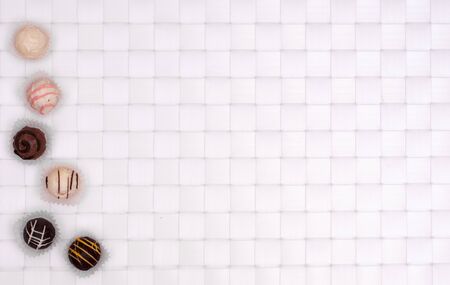White and brown filled chocolates on a white squared backgroundの写真素材