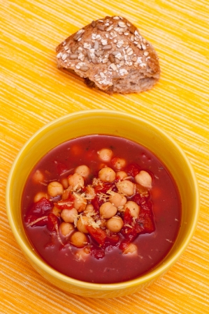 Soup with tomatoes, chick peas and lemon peel in a yellow bowlの写真素材