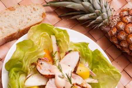 Salad with chicken and fruits on a plateの写真素材