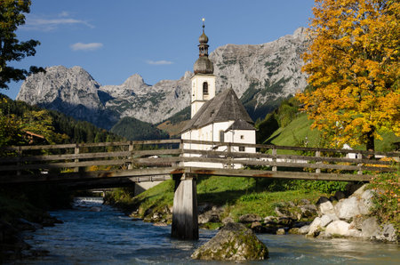 Church in Ramsau with mountain brook and wooden bridge
