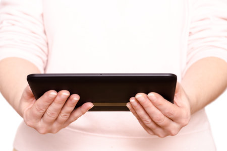 Two female hands are holding a tablet computer