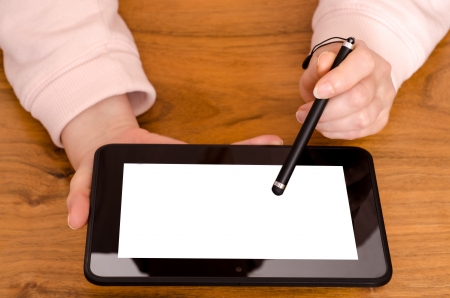 Two female hands with a touch pen on a tablet computerの写真素材