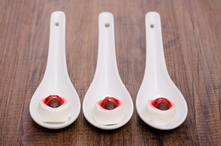 Three spoons with soft goat cheese and ladybirds of sugarの写真素材
