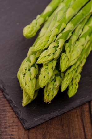 Raw green asparagus on black slateの写真素材