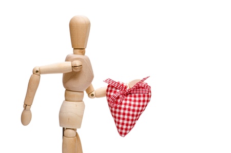 Male wooden figure is holding a red checkered heartの写真素材