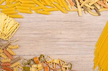 Different italian pasta with text space on a wooden boardの写真素材