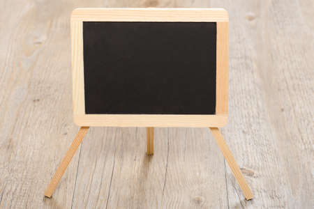 Blackboard on a wooden floor with text space for advertisingの写真素材