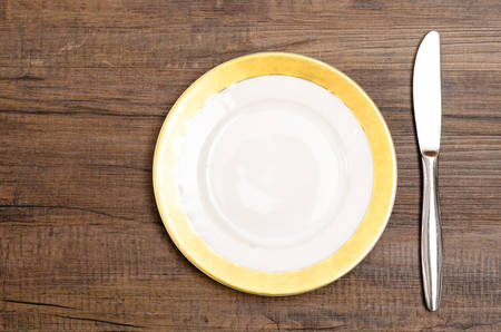 Porcelain dessert plate with knife on a wooden tableの写真素材