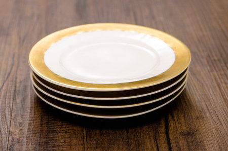 Four little plate with gold edge on a stack