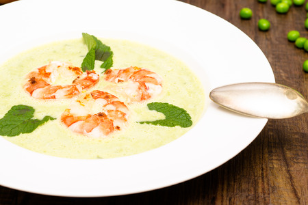 Pea soup wit shrimps and green mint leafsの写真素材
