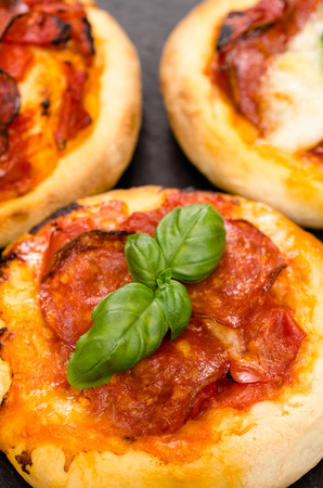 Close up of pizza with salami sausage and basil in vertical formatの写真素材