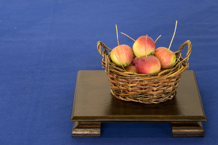 Basket with ripe red apples from a wild apple on a wooden tableの写真素材