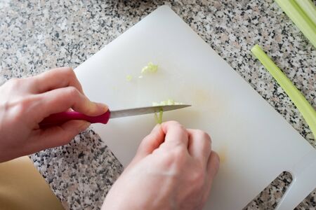 Topviwe hands chopping with a vegetable knife green celeriacの写真素材