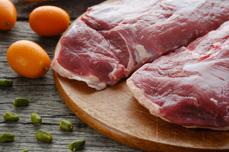 Raw duck breast with ingredients kumquat and pistachio nuts for a recipeの写真素材