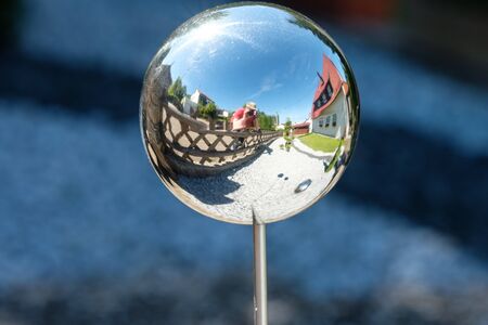 House, fence and photographer as mirroring in a glass ballの写真素材