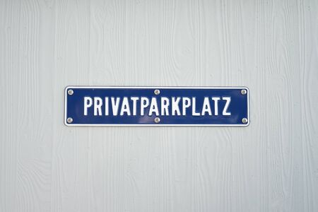 Blue private parking sign at a white wallの写真素材