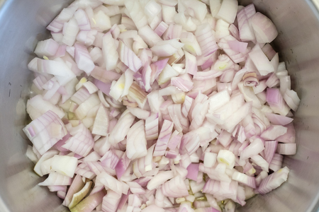 Vegetable onions sweating in a stainless steel cooking potの写真素材