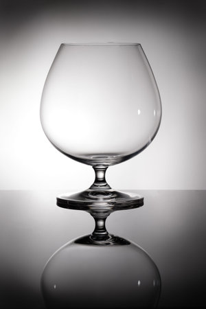 Brandy and Cognac glass in back lit with reflectionの写真素材
