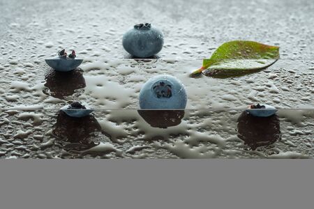 Blueberries with leaf and water in back litの写真素材