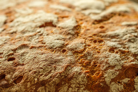Crust of bread with flour in back lit close-up