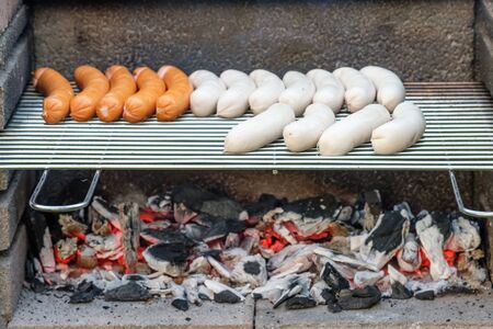 Roast sausage on a grill with coalの写真素材