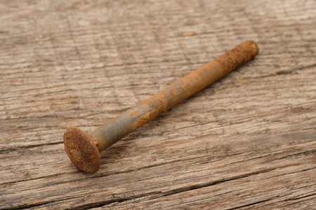 Rusty metal screw on rustic wood close up